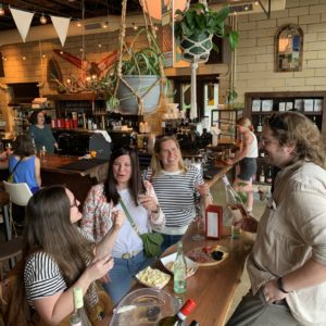 Group of people gathered around a table tasting wine